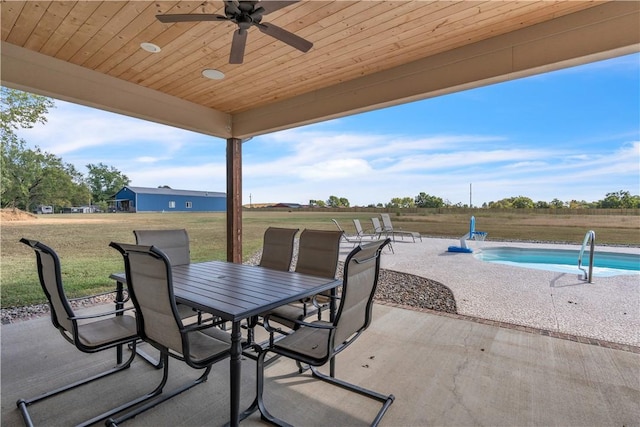 view of patio with outdoor dining space, an outdoor pool, and a ceiling fan