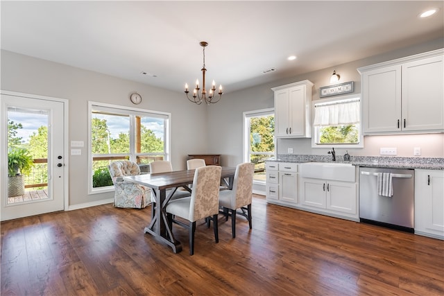 dining space with an inviting chandelier, sink, and dark hardwood / wood-style flooring