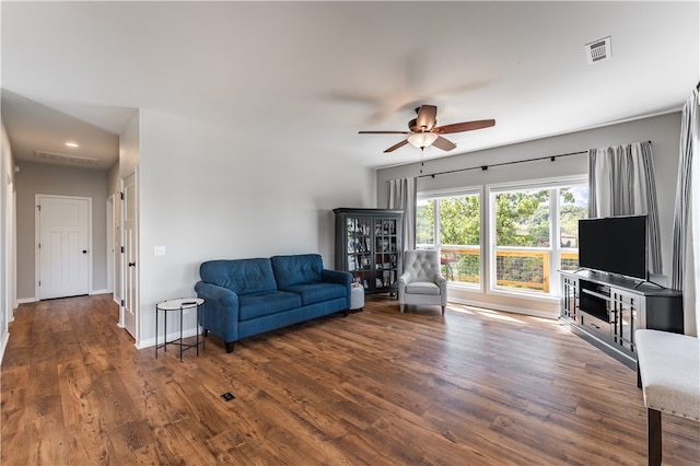 living room featuring ceiling fan and dark wood-type flooring