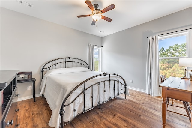 bedroom with dark hardwood / wood-style flooring and ceiling fan