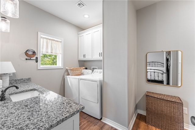 washroom featuring cabinets, light hardwood / wood-style flooring, separate washer and dryer, and sink