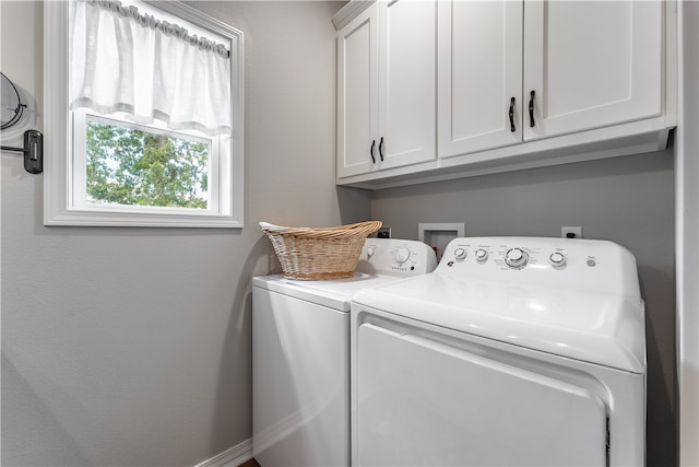 laundry area featuring separate washer and dryer and cabinets