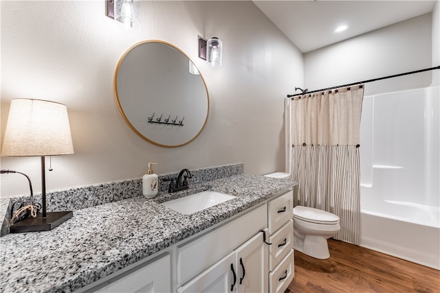 full bathroom with wood-type flooring, shower / tub combo with curtain, vanity, and toilet