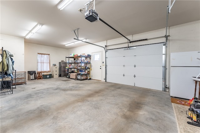 garage featuring a garage door opener and white fridge