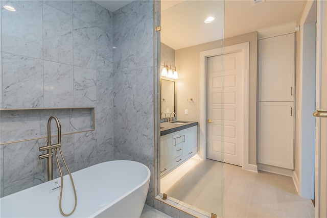 bathroom with tile walls, tile patterned flooring, vanity, and a washtub