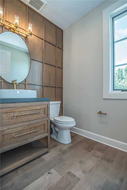 bathroom featuring wood-type flooring, vanity, and toilet