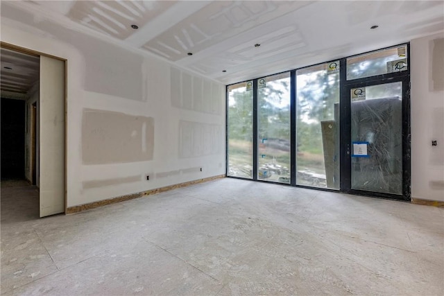 spare room with baseboards and floor to ceiling windows