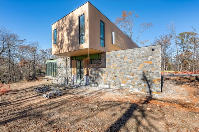 back of house featuring stone siding