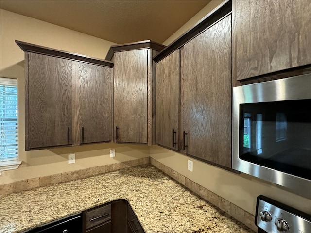 room details with light stone countertops and dark brown cabinets