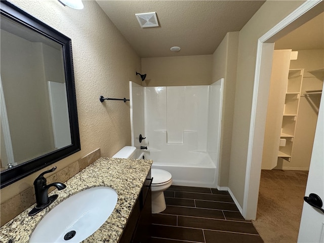 full bathroom featuring vanity, a textured ceiling, shower / bathtub combination, hardwood / wood-style flooring, and toilet