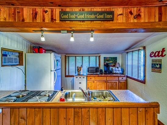 kitchen with a wall mounted air conditioner, stainless steel appliances, and sink