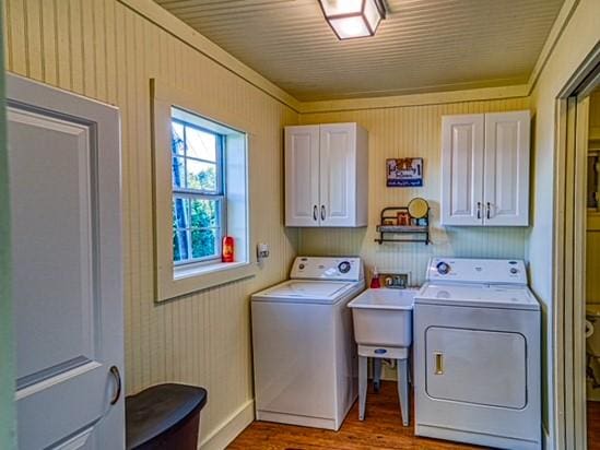 laundry room with separate washer and dryer, sink, cabinets, and light wood-type flooring