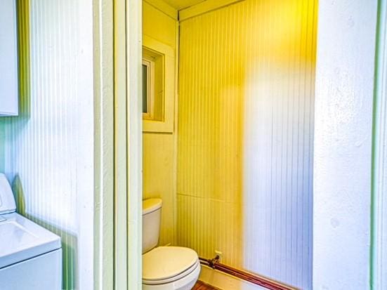 bathroom with toilet and washer / dryer