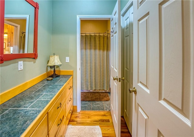 bathroom featuring a shower with shower curtain, hardwood / wood-style floors, and vanity