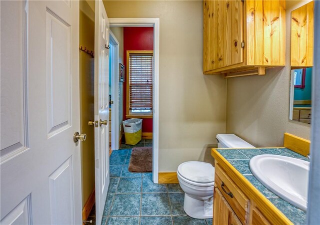 bathroom featuring tile patterned floors, vanity, and toilet