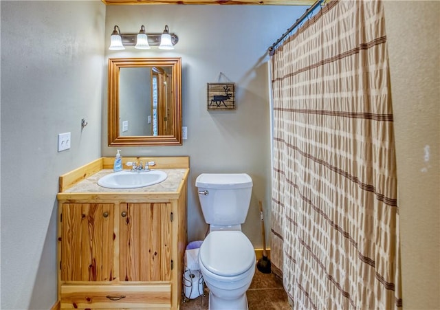 bathroom featuring tile patterned flooring, vanity, toilet, and walk in shower