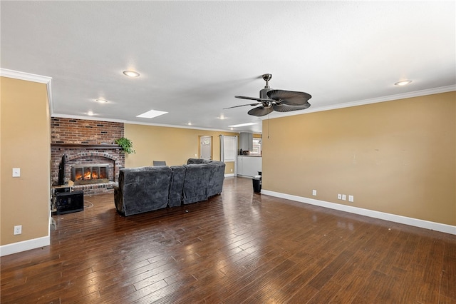 living room featuring a brick fireplace, ceiling fan, crown molding, and dark hardwood / wood-style flooring