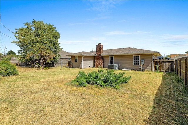 back of house featuring central AC unit and a yard