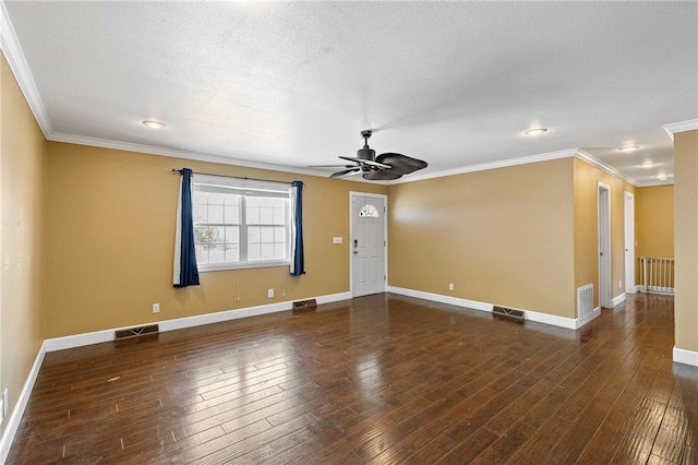 empty room with a textured ceiling, crown molding, and dark hardwood / wood-style flooring