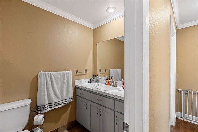 bathroom with ornamental molding, toilet, and vanity