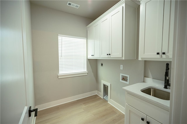 washroom with sink, electric dryer hookup, washer hookup, cabinets, and light hardwood / wood-style flooring