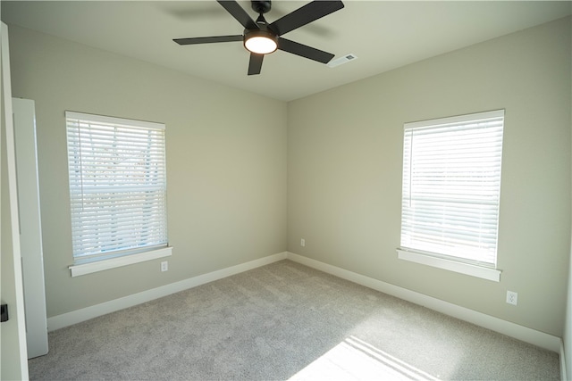 spare room with ceiling fan and light colored carpet