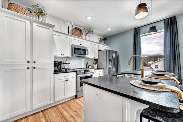 kitchen featuring pendant lighting, white cabinetry, appliances with stainless steel finishes, and sink