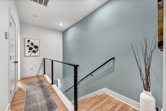 stairs featuring hardwood / wood-style floors