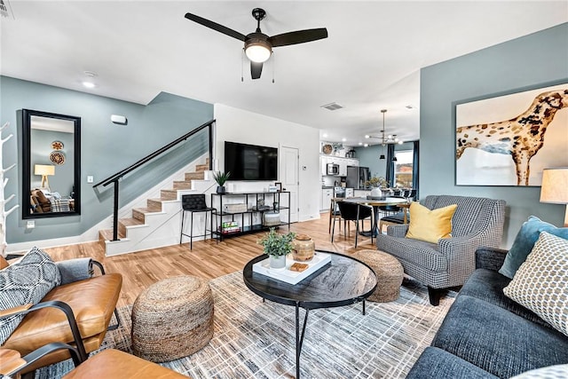 living room with ceiling fan and light hardwood / wood-style floors