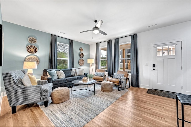 living room with ceiling fan and light hardwood / wood-style flooring