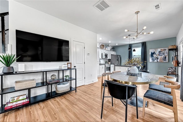 dining area featuring an inviting chandelier and light wood-type flooring