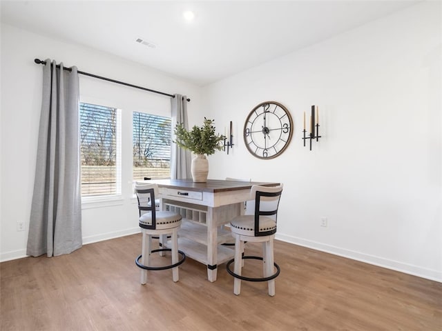 dining space with hardwood / wood-style floors