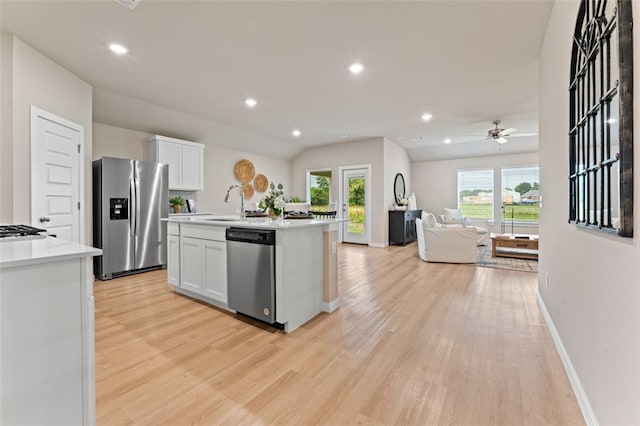 kitchen with white cabinets, an island with sink, stainless steel appliances, and a healthy amount of sunlight