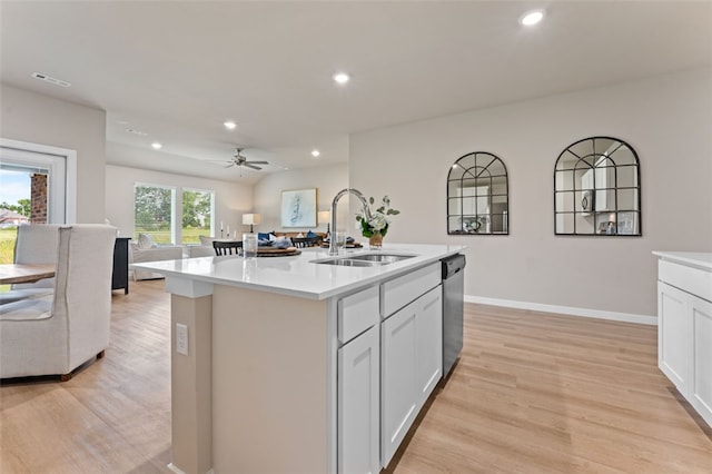 kitchen with stainless steel dishwasher, a center island with sink, light hardwood / wood-style floors, and sink