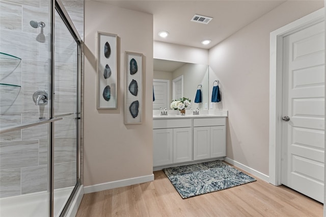 bathroom with a shower with door, vanity, and hardwood / wood-style flooring