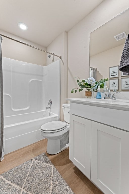 full bathroom with washtub / shower combination, vanity, toilet, and hardwood / wood-style flooring