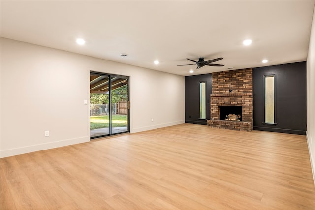 unfurnished living room with light wood-type flooring, ceiling fan, and a fireplace