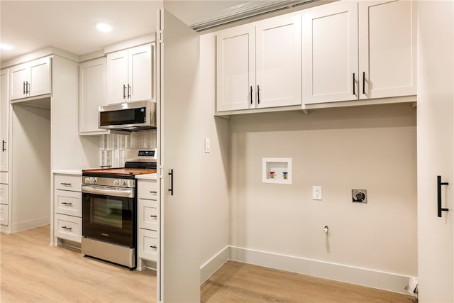 kitchen featuring white cabinets, stainless steel appliances, and light hardwood / wood-style flooring