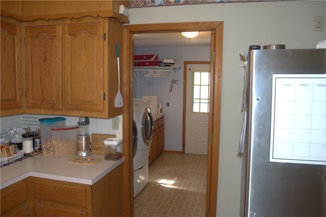 kitchen featuring backsplash, refrigerator, plenty of natural light, and washing machine and dryer