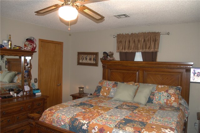 bedroom with ceiling fan and a textured ceiling