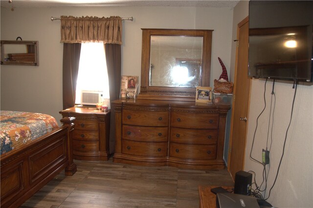 bedroom featuring a textured ceiling, cooling unit, and dark hardwood / wood-style flooring