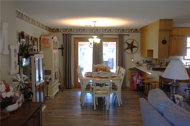 dining room featuring a textured ceiling, hardwood / wood-style floors, and a chandelier