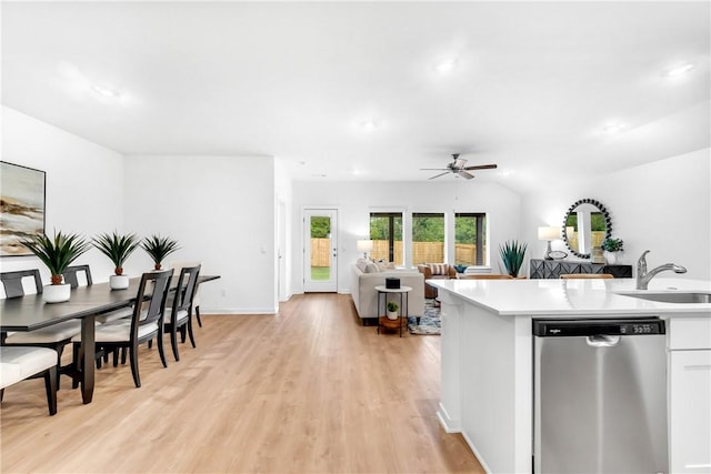 kitchen with a sink, light wood finished floors, dishwasher, ceiling fan, and light countertops