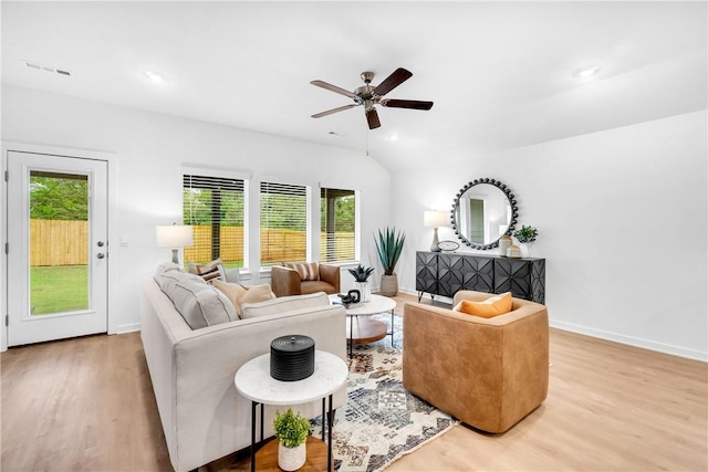 living room featuring wood finished floors, baseboards, visible vents, lofted ceiling, and ceiling fan