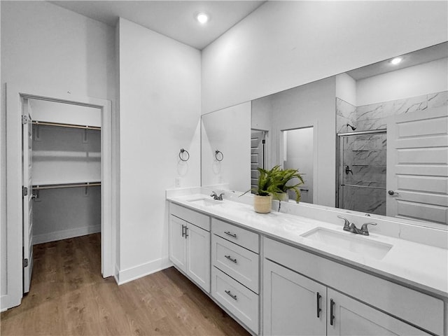 bathroom featuring wood-type flooring, vanity, and an enclosed shower