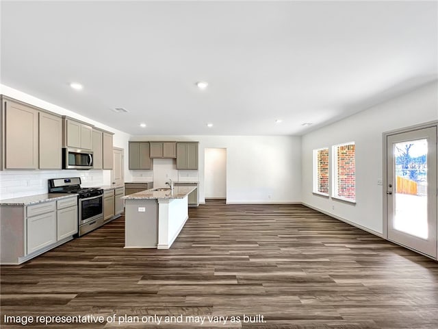 kitchen with gray cabinetry, a center island with sink, sink, dark hardwood / wood-style floors, and appliances with stainless steel finishes