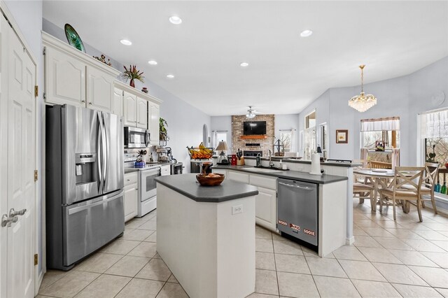 kitchen with white cabinets, pendant lighting, sink, kitchen peninsula, and appliances with stainless steel finishes