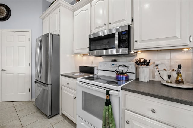 kitchen with white cabinets, light tile patterned flooring, stainless steel appliances, and decorative backsplash