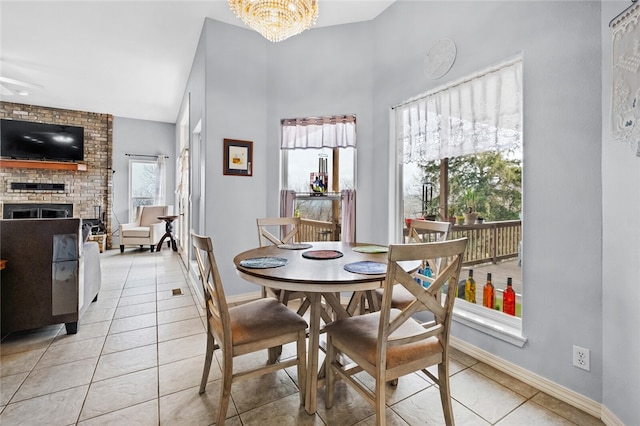 dining room featuring a fireplace, light tile patterned floors, and a wealth of natural light