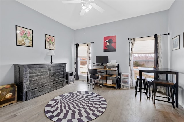 office area with ceiling fan, light wood-type flooring, and a wealth of natural light